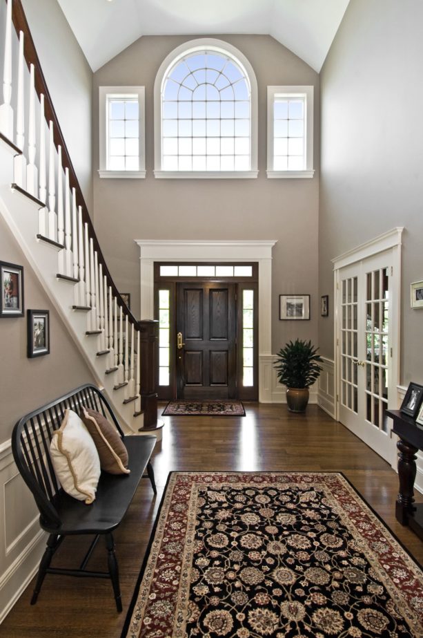 a historical feel in a traditional entry with dark-stained walnut floor and white trim
