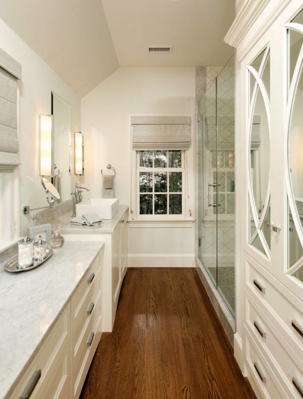 a narrow traditional bathroom with white trim and dark wood floor