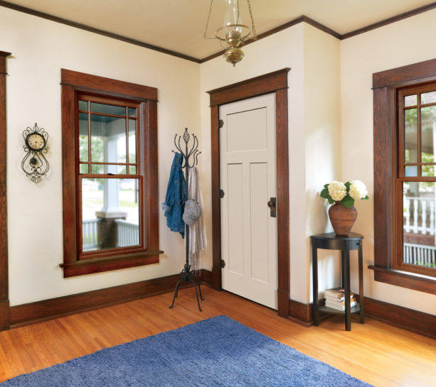 a traditional interior with off-white door and stained oak wood trim