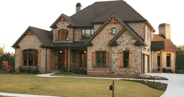 brown brick home exterior with wood-color shutters