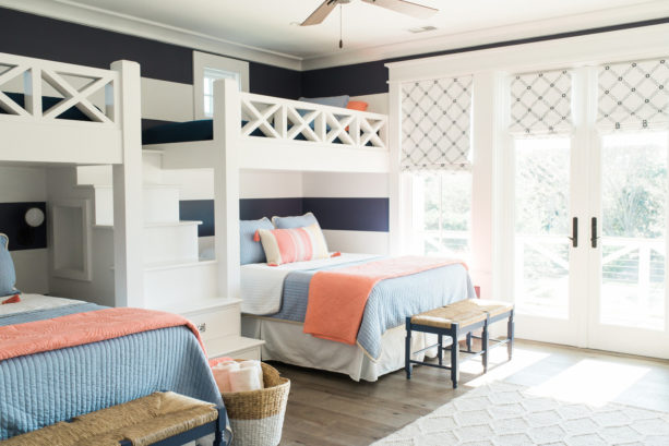 coral and blue shared bedroom with white and navy blue horizontal stripes wall design
