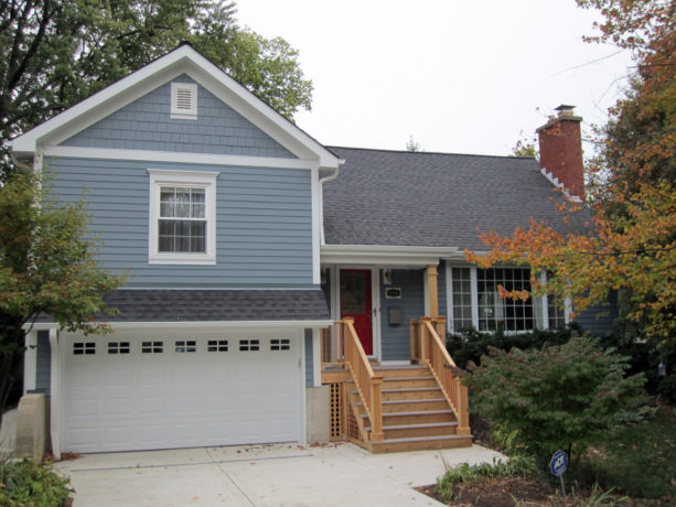 a slate blue house with white trim and currant red front door