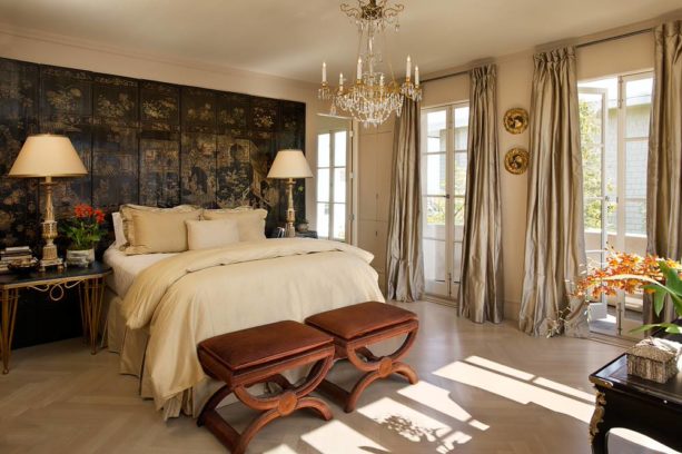 a traditional bedroom with black and gold accent wall and gold curtains