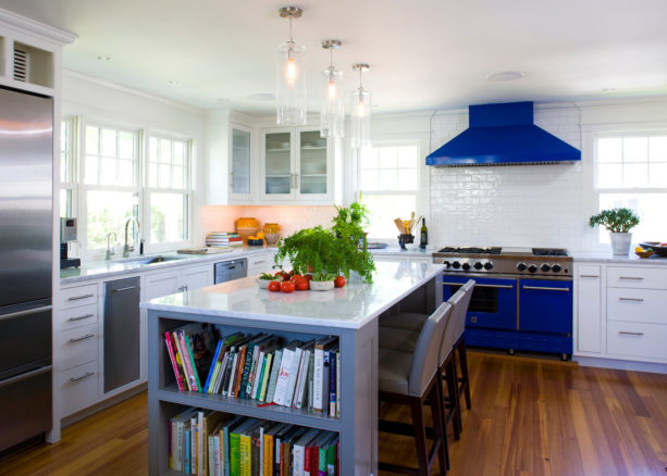 blue stove and range hood with white subway tile backsplash with white grout