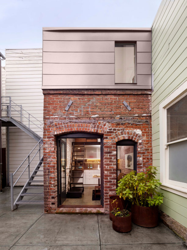 a charming contemporary facade with tan siding and red brick combination