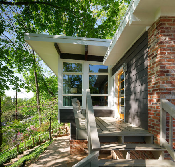 a contemporary exterior with red brick and charcoal grey siding combination
