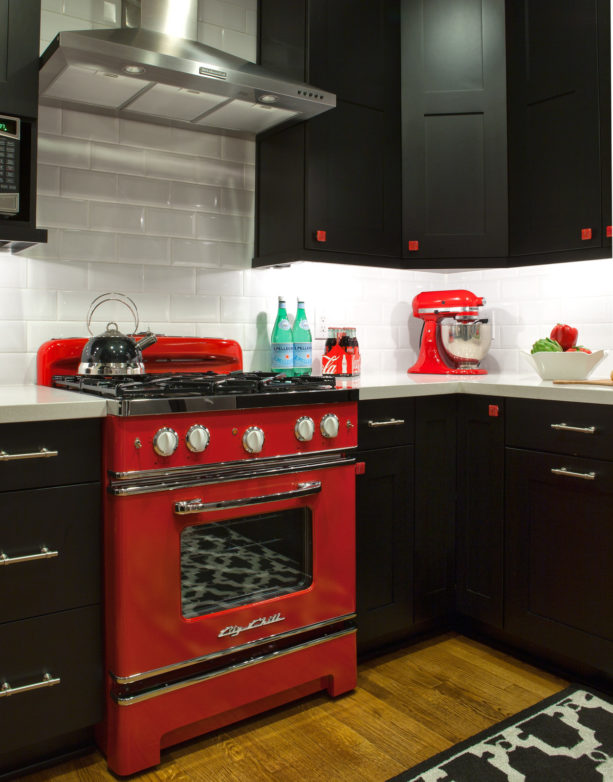 a red kitchen range with black grate and chrome accents