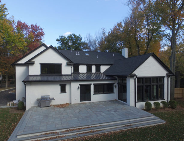 a transitional white house with black roof and trim
