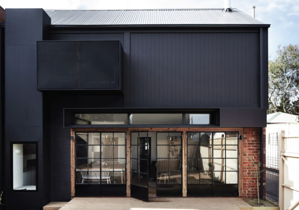 the combination of black siding, red brick, and glass doors