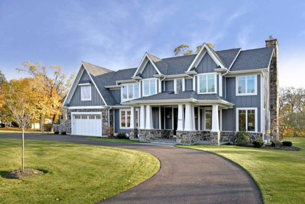 a gray craftsman exterior design with white trim and grey-color natural stone