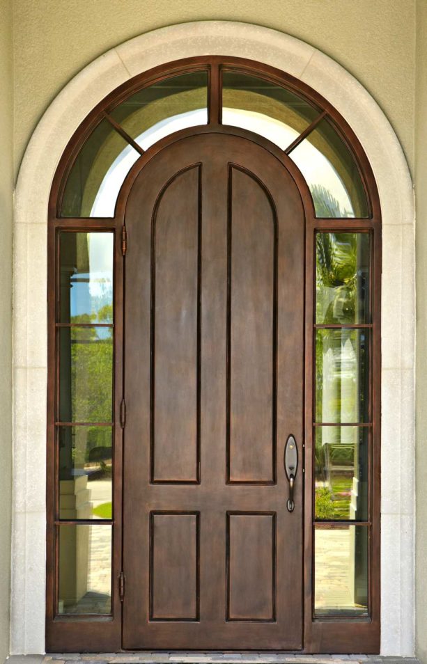a traditional entry solid wood door with transom surround by Sun Coast Iron Doors