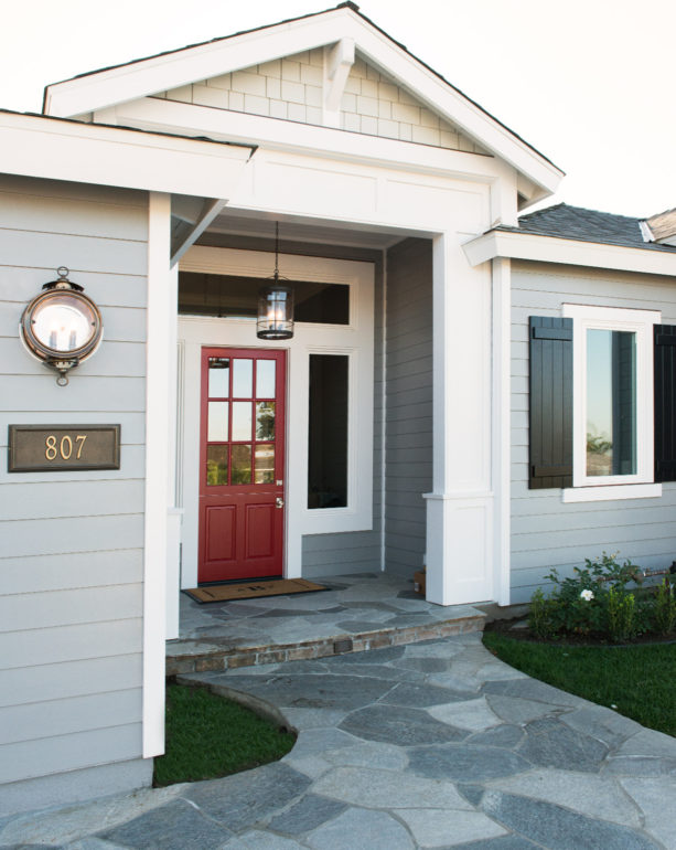 berry-red front door in a light grey exterior with white trim