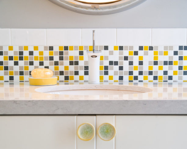 fresh look with grey, white, and yellow mosaic tile for the backsplash