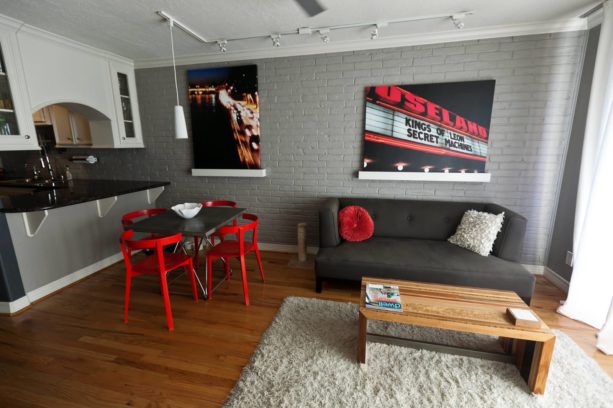 textured grey brick walls and red details in a modern dining-living room