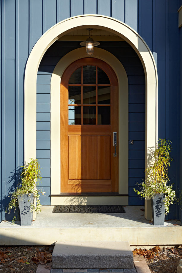 a traditional wooden arched front door with simple trim