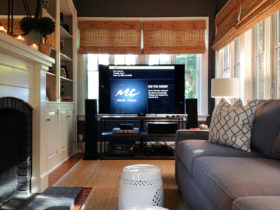 a large TV with complete entertainment equipment in front of the window
