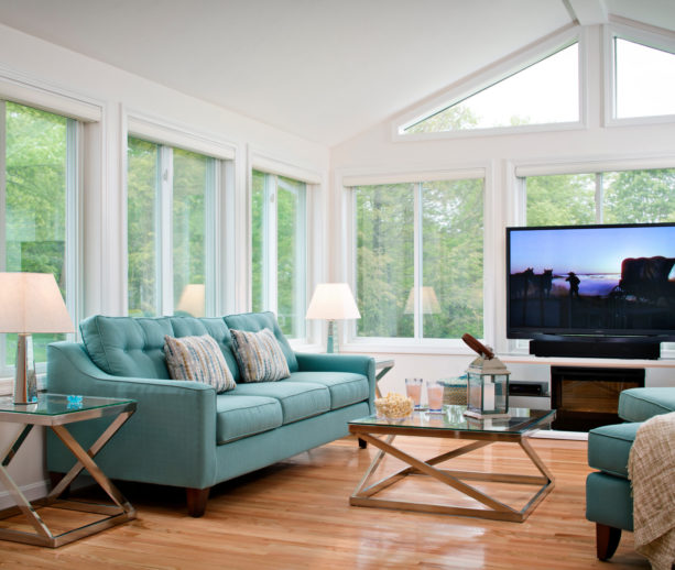 a large traditional sunroom with a large TV in front of the window