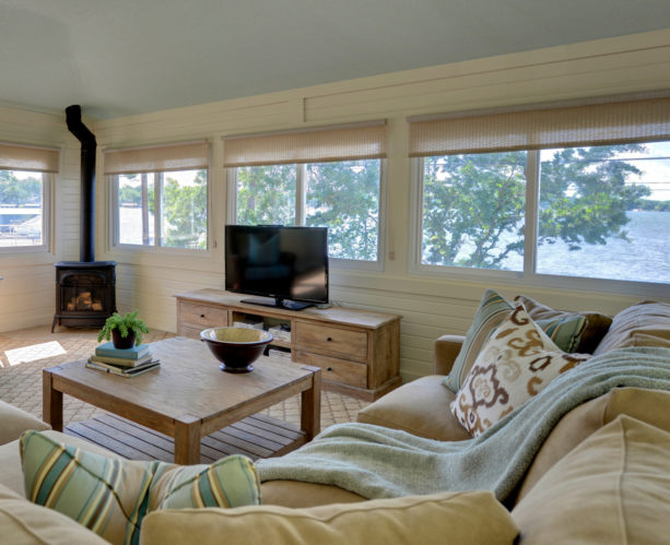 a transitional sunroom with roll-up woven blinds to reduce glare and heat for better TV-viewing