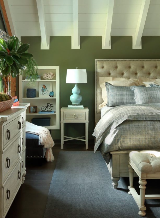 a bed with gray bedding set in a bedroom dominated with green