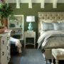 a bed with gray bedding set in a bedroom dominated with green
