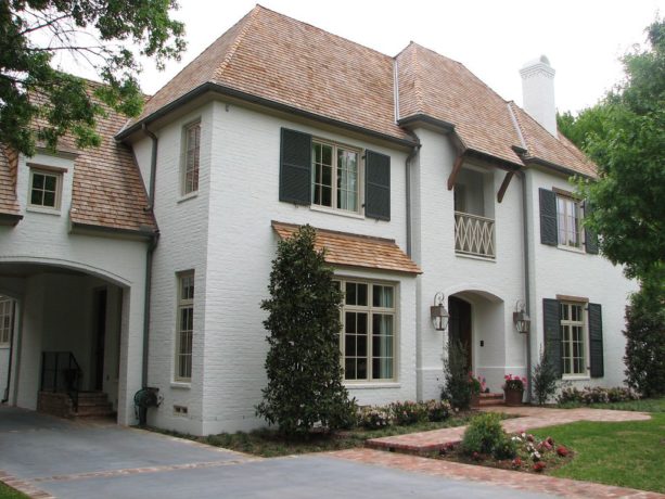 white painted brick and brown roof shingles combination in a traditional home exterior