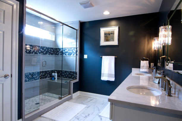 a luxurious bathroom with navy blue focal point wall combined with white countertop