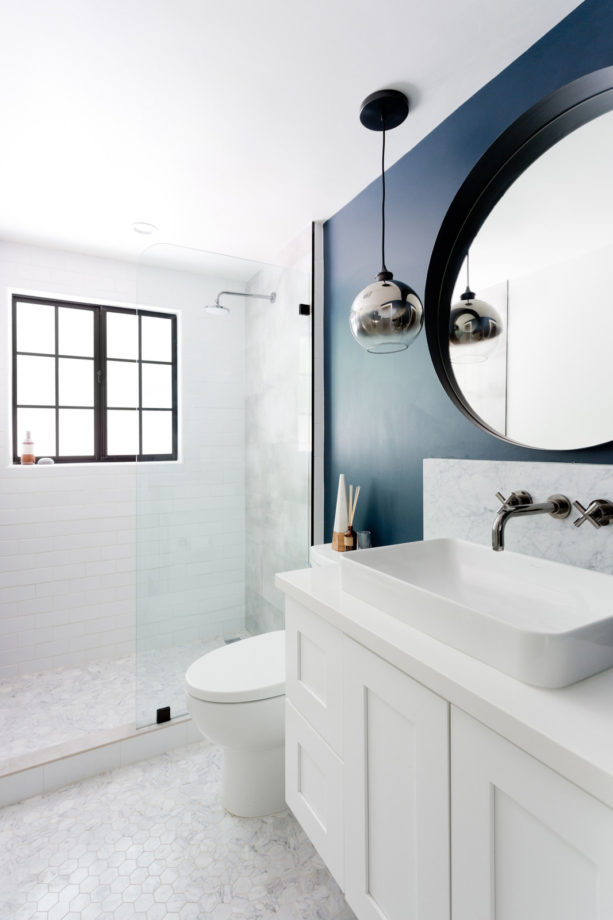 a small transitional clean bathroom with dark blue and white combination to look fierce