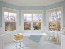a traditional bathroom with soft blue walls and white tile porcelains to give a relaxing sensation