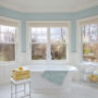 a traditional bathroom with soft blue walls and white tile porcelains to give a relaxing sensation