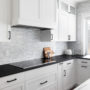 u-shaped shaker white cabinets and black granite countertops in a contemporary kitchen