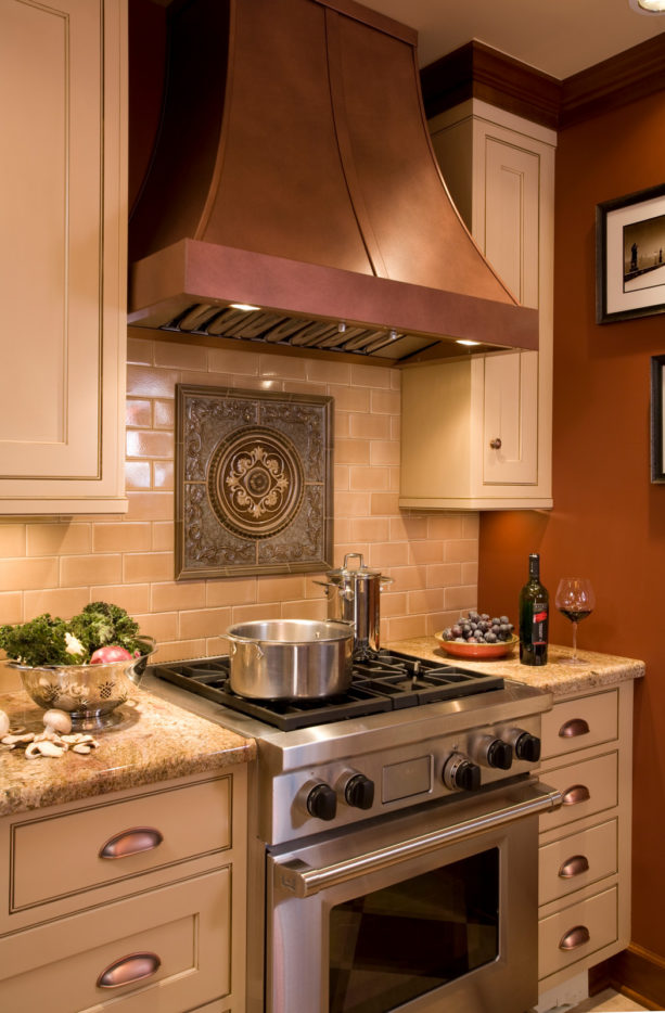 english tudor kitchen with antique medallion backsplash behind stove only