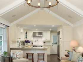crisp white small peninsula kitchen and classic living room combo