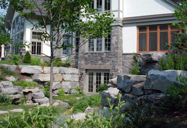 nice option of triple walkout basement door in a stack of natural stone wall