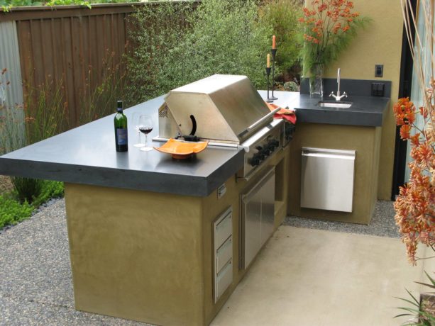 small outdoor kitchen with l-shaped layout featuring smooth wall stucco for a trendy look
