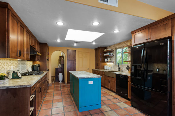 terracotta tile kitchen color combined with turquoise island and brown cabinets to achieve a neutral yet striking look