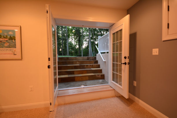 wide glass panel walkout basement doors option in white frame and dark hardware