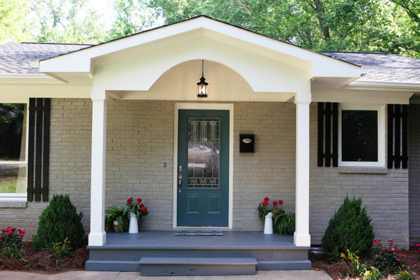 classic front porch in a ranch style home with gray brick exterior