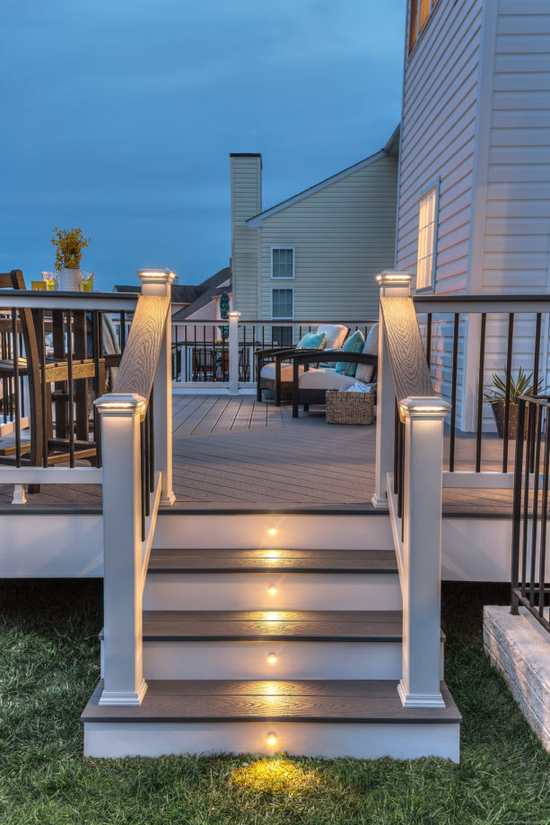 classic white and pebble gray stair with post cap and stair riser outdoor lighting