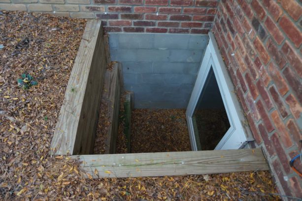 combination of wood, concrete, and brick of a basement window well