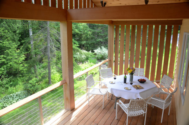 small covered deck with cedar board vertical wood slat wall as a screen