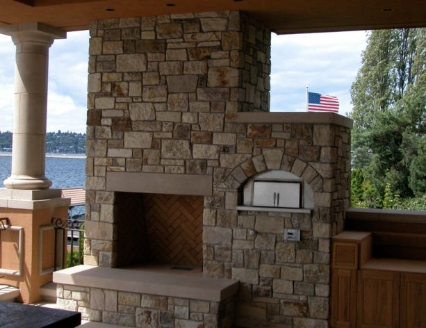 stacked of outdoor stone fireplace with a side pizza oven
