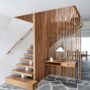 wooden staircase in an open and l-shaped design with a vertical wood slat wall