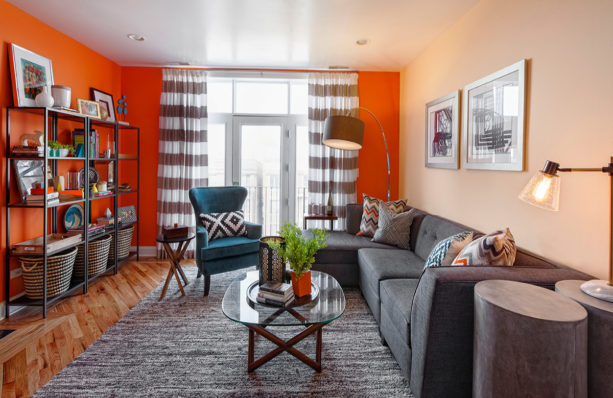combination of aurora orange and beige wall and turquoise blue chair in a trendy living room