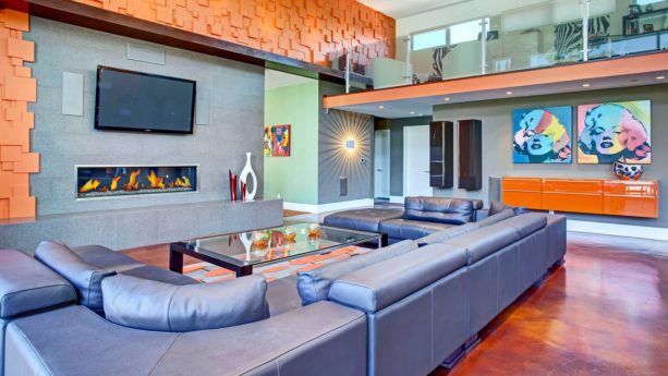 exuberant orange wall and silvery blue sectional in an open concept living room
