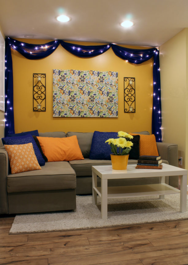 small living room with sheer blue chiffon framing the orange wall