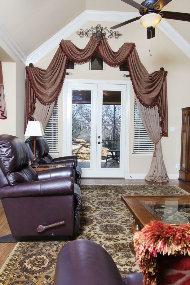 bold panels, arched swags, and jabots window treatment for french door to a patio