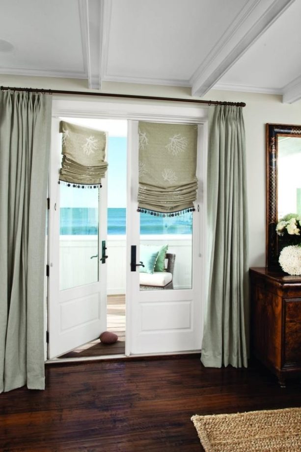 casual roman shades framed with drapery as a window treatment for a french door to a patio