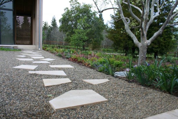 grey colored pea gravel walkway paired with random sized stepping stones