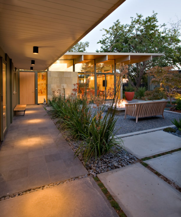 midcentury small backyard patio with a roof extension and concrete paver