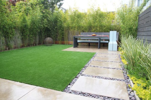 modern landscape with artificial grass, pea gravel walkway, and polished concrete stepping stones